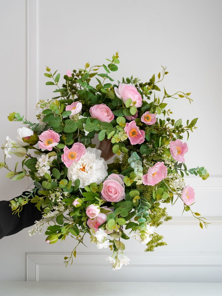 różowy wianek na drzwi ze sztucznych kwiatów